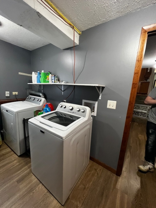 laundry area with washer and dryer, wood-type flooring, and a textured ceiling