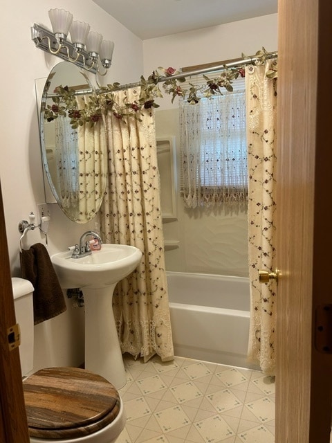 bathroom with shower / bathtub combination with curtain and toilet