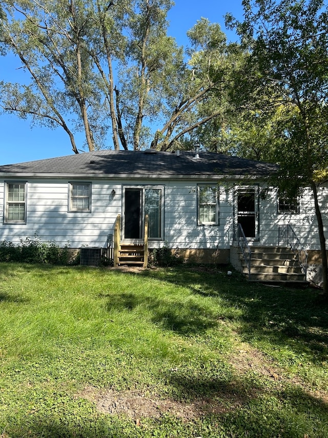 rear view of property with a lawn