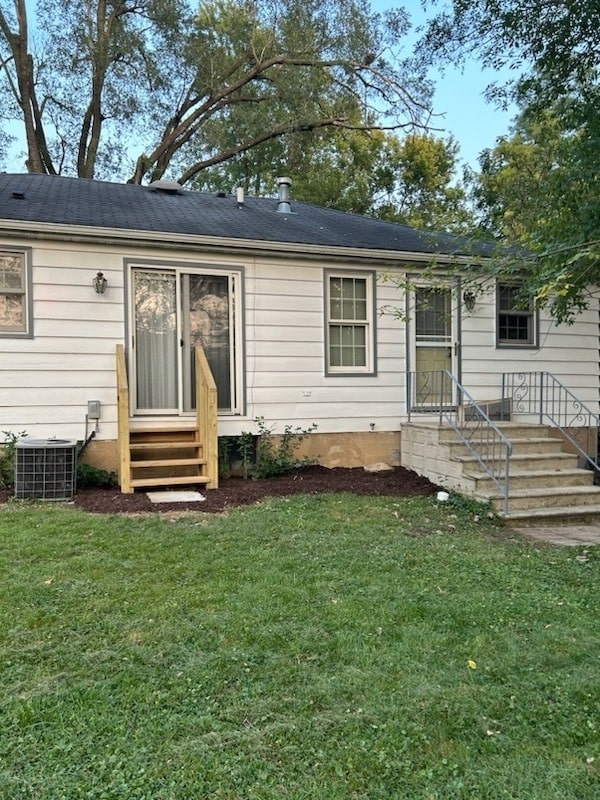 back of house featuring a yard and central AC