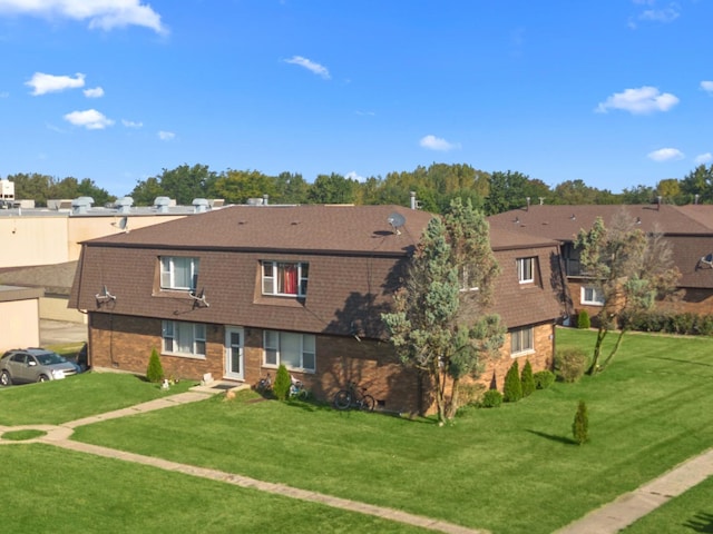 exterior space with brick siding and a front yard