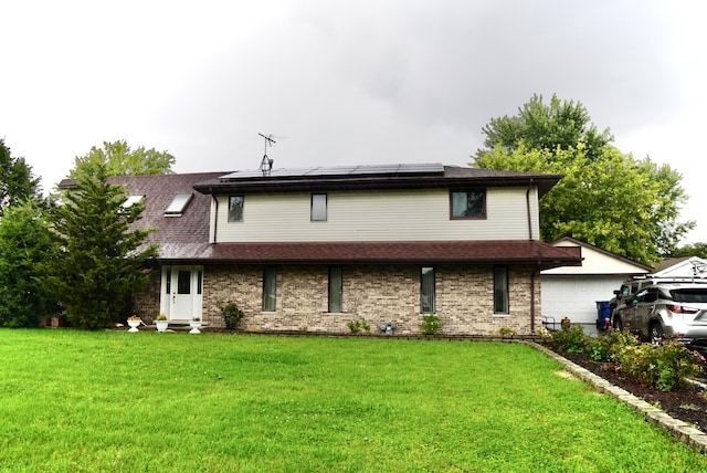 back of property with a lawn and a garage