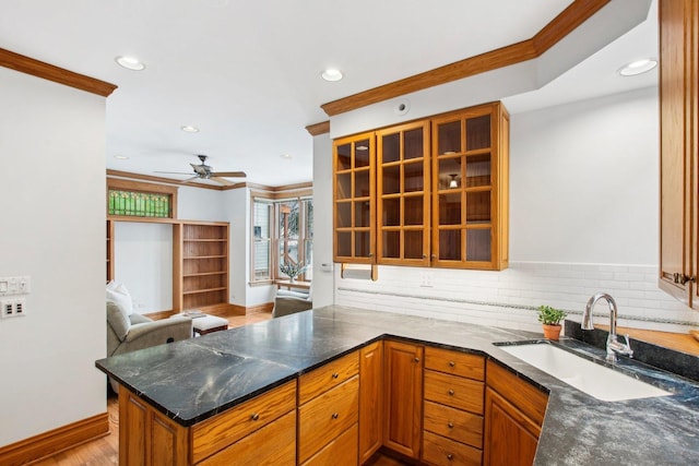 kitchen featuring kitchen peninsula, sink, and ornamental molding