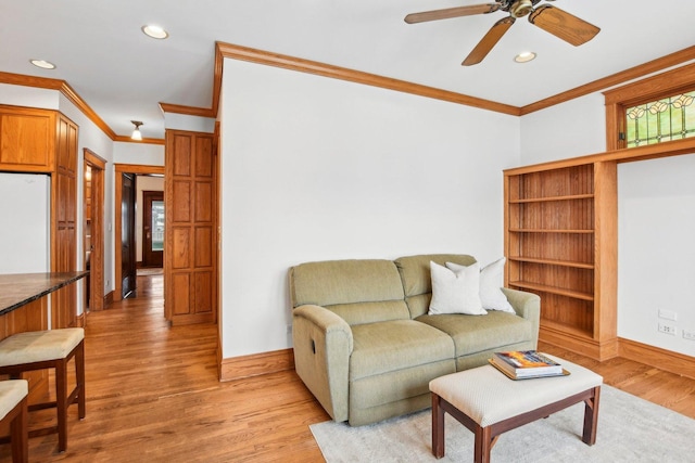 living room featuring light hardwood / wood-style floors, ceiling fan, and ornamental molding