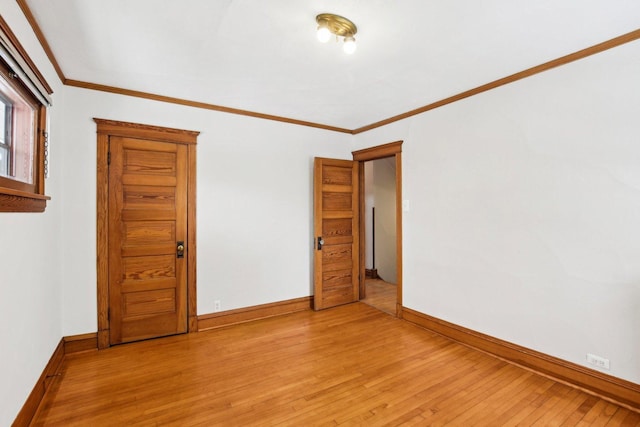 spare room featuring ornamental molding and light wood-type flooring