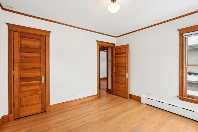 empty room with baseboard heating, crown molding, and light hardwood / wood-style floors