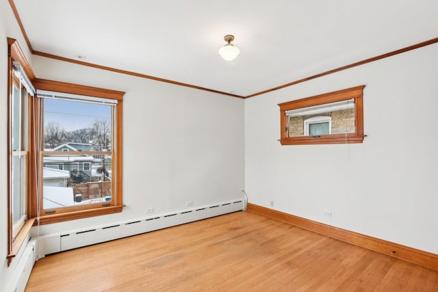 empty room featuring baseboard heating, crown molding, and light hardwood / wood-style flooring