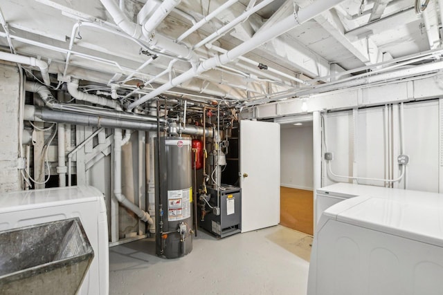 basement featuring washing machine and clothes dryer, sink, and water heater