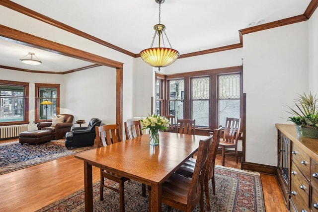 dining space featuring hardwood / wood-style flooring, ornamental molding, and radiator