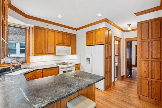 kitchen featuring kitchen peninsula, decorative backsplash, white appliances, sink, and light hardwood / wood-style flooring