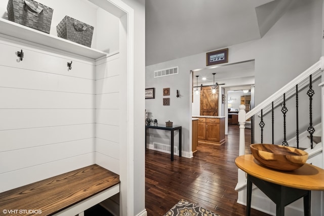 mudroom with a barn door and dark hardwood / wood-style floors