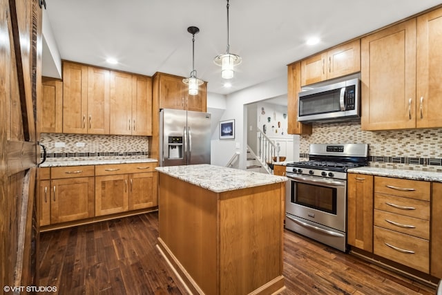 kitchen featuring a center island, stainless steel appliances, dark hardwood / wood-style floors, and hanging light fixtures