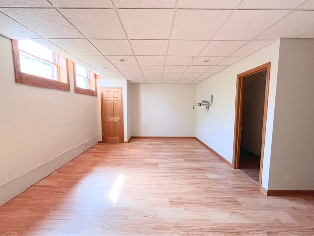 basement featuring light wood-type flooring and a drop ceiling