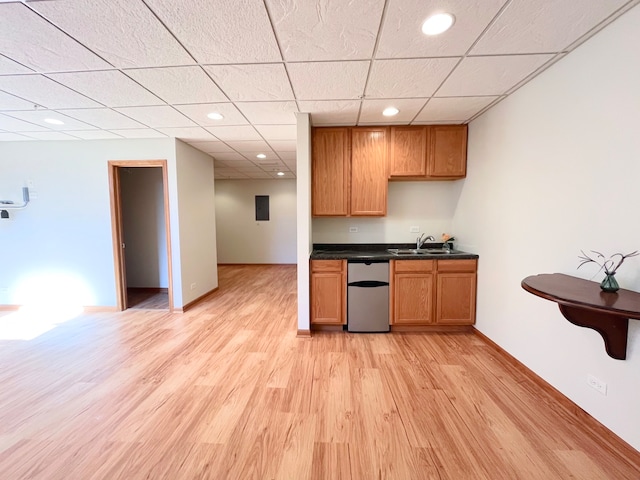 kitchen featuring a drop ceiling, light hardwood / wood-style flooring, stainless steel dishwasher, and sink