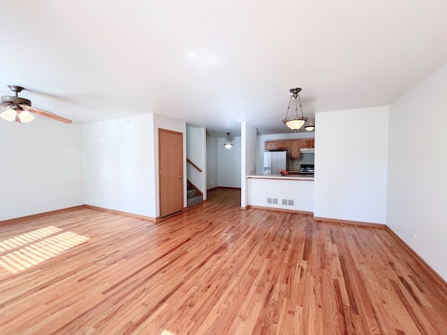 unfurnished living room featuring ceiling fan and light hardwood / wood-style floors