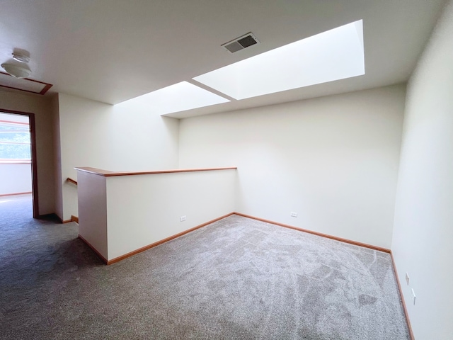 unfurnished room featuring carpet flooring and a skylight