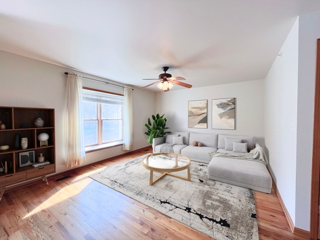 living room with light hardwood / wood-style flooring and ceiling fan