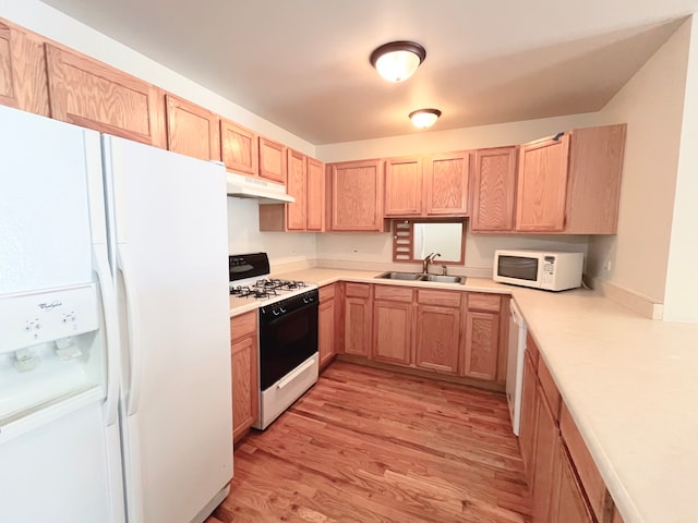 kitchen featuring light wood-type flooring, light brown cabinetry, sink, and white appliances