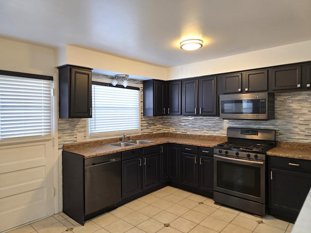 kitchen with light tile patterned floors, decorative backsplash, sink, and stainless steel appliances