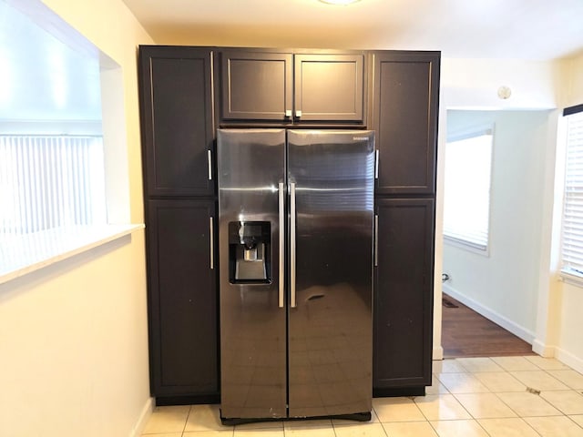 kitchen with dark brown cabinetry, stainless steel fridge with ice dispenser, and light tile patterned flooring