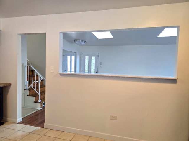 tiled spare room featuring a skylight