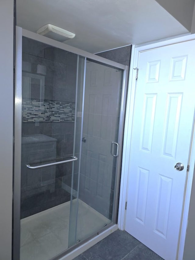 bathroom featuring a shower with shower door and tile patterned floors