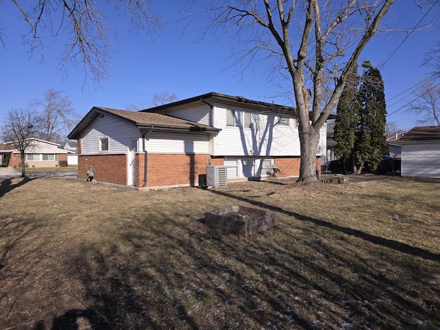 view of home's exterior with cooling unit and a yard