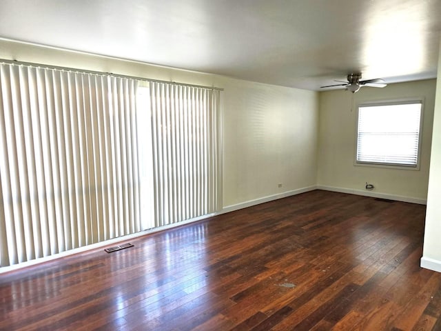 empty room with ceiling fan and dark hardwood / wood-style flooring