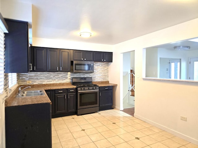 kitchen with backsplash, sink, a healthy amount of sunlight, stainless steel appliances, and light tile patterned floors