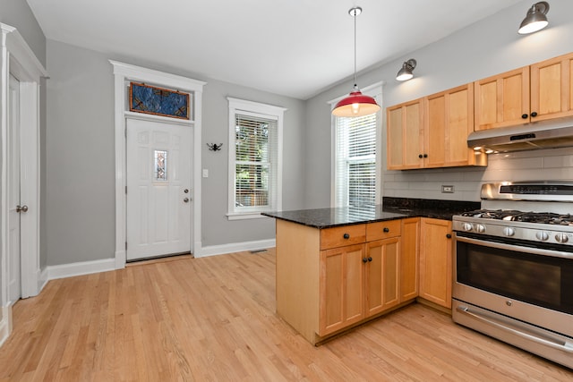 kitchen with pendant lighting, kitchen peninsula, stainless steel gas stove, light hardwood / wood-style flooring, and decorative backsplash