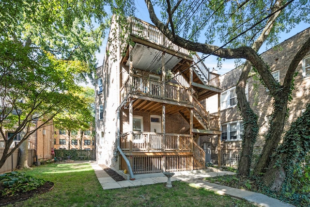 back of property with a wooden deck and a lawn