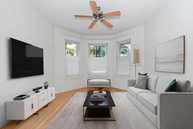 living room featuring ceiling fan, light hardwood / wood-style flooring, and a healthy amount of sunlight