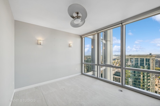 carpeted empty room featuring floor to ceiling windows and ceiling fan