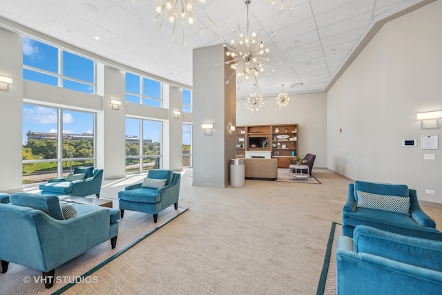 carpeted living room featuring a towering ceiling and an inviting chandelier