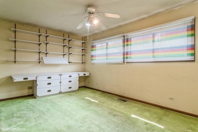 unfurnished office featuring ceiling fan and light carpet