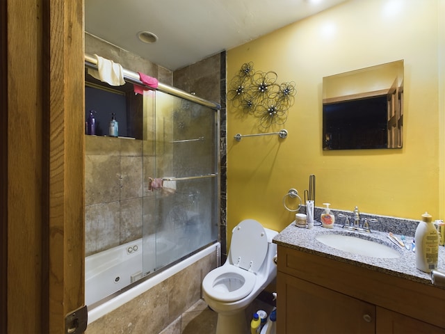 full bathroom with toilet, bath / shower combo with glass door, and vanity