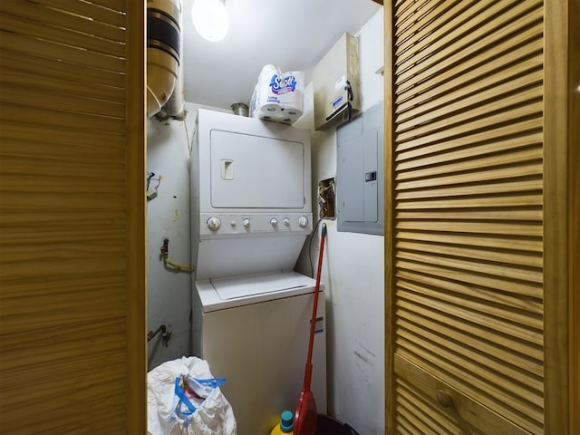 laundry area featuring electric panel and stacked washer and clothes dryer