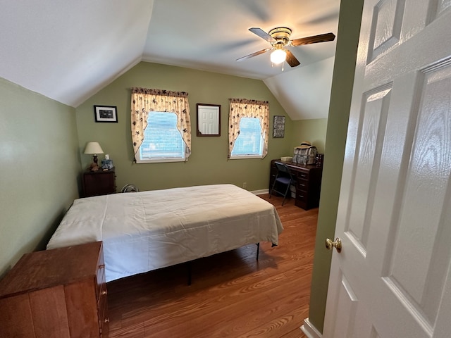 bedroom featuring wood-type flooring, vaulted ceiling, and ceiling fan