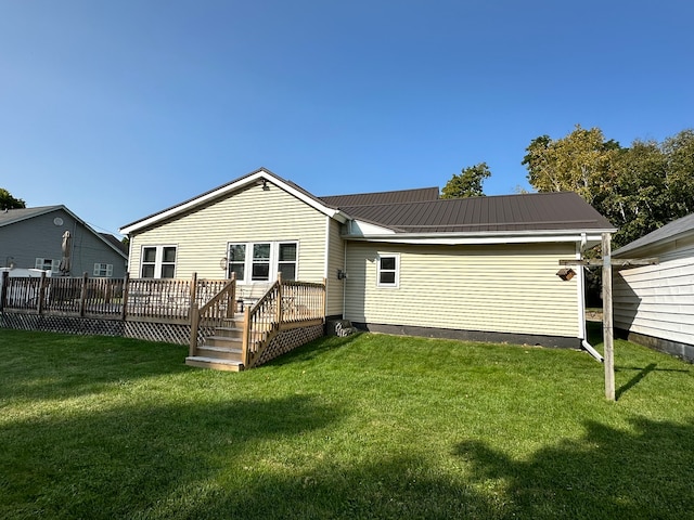 back of property with a deck and a lawn