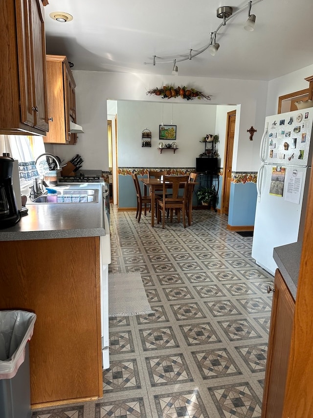 kitchen with white fridge and rail lighting