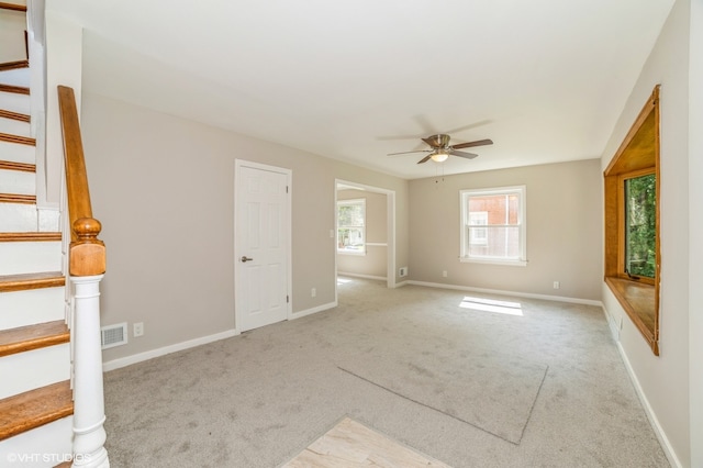 interior space with ceiling fan and light carpet