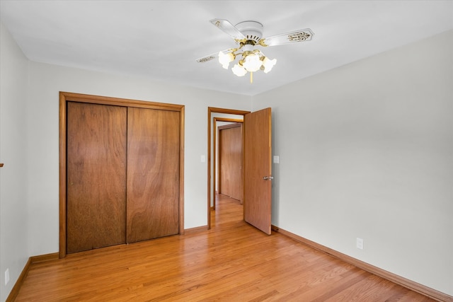 unfurnished bedroom featuring ceiling fan, a closet, and light hardwood / wood-style flooring