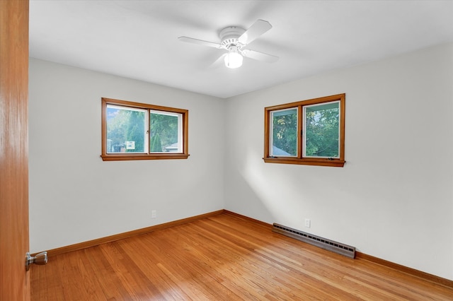 spare room with light wood-type flooring, ceiling fan, and baseboard heating