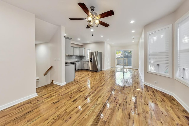 unfurnished living room with ceiling fan and light wood-type flooring