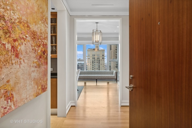 hall featuring a notable chandelier and light hardwood / wood-style floors