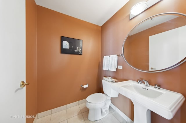 bathroom featuring toilet, sink, and tile patterned floors