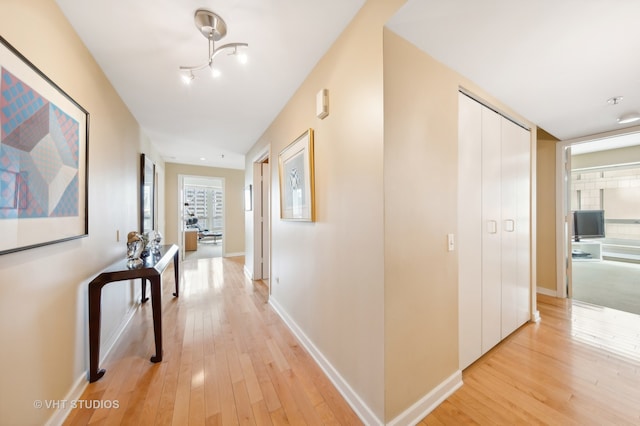 hallway featuring an inviting chandelier and light wood-type flooring