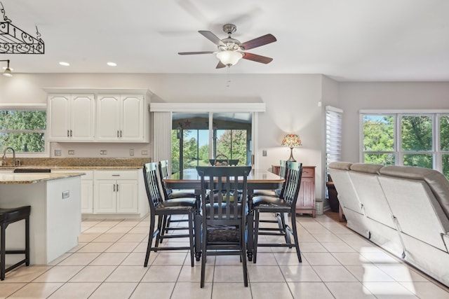 kitchen with light stone countertops, ceiling fan, white cabinetry, and light tile patterned flooring