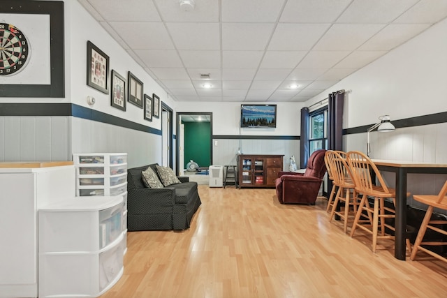 living room with a paneled ceiling and hardwood / wood-style floors