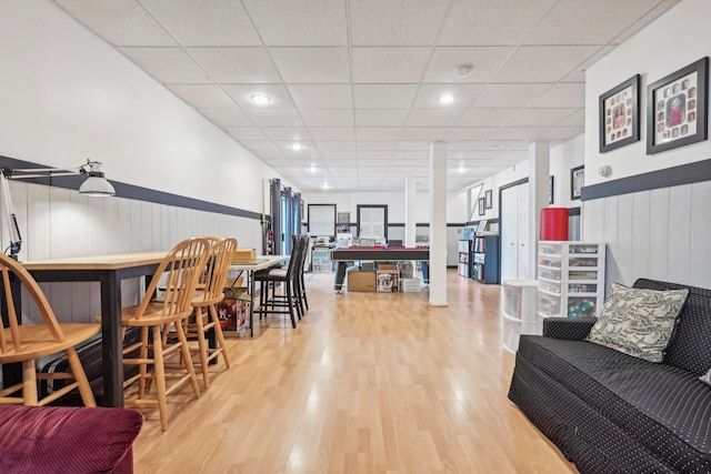 dining room featuring bar area, a drop ceiling, and hardwood / wood-style floors